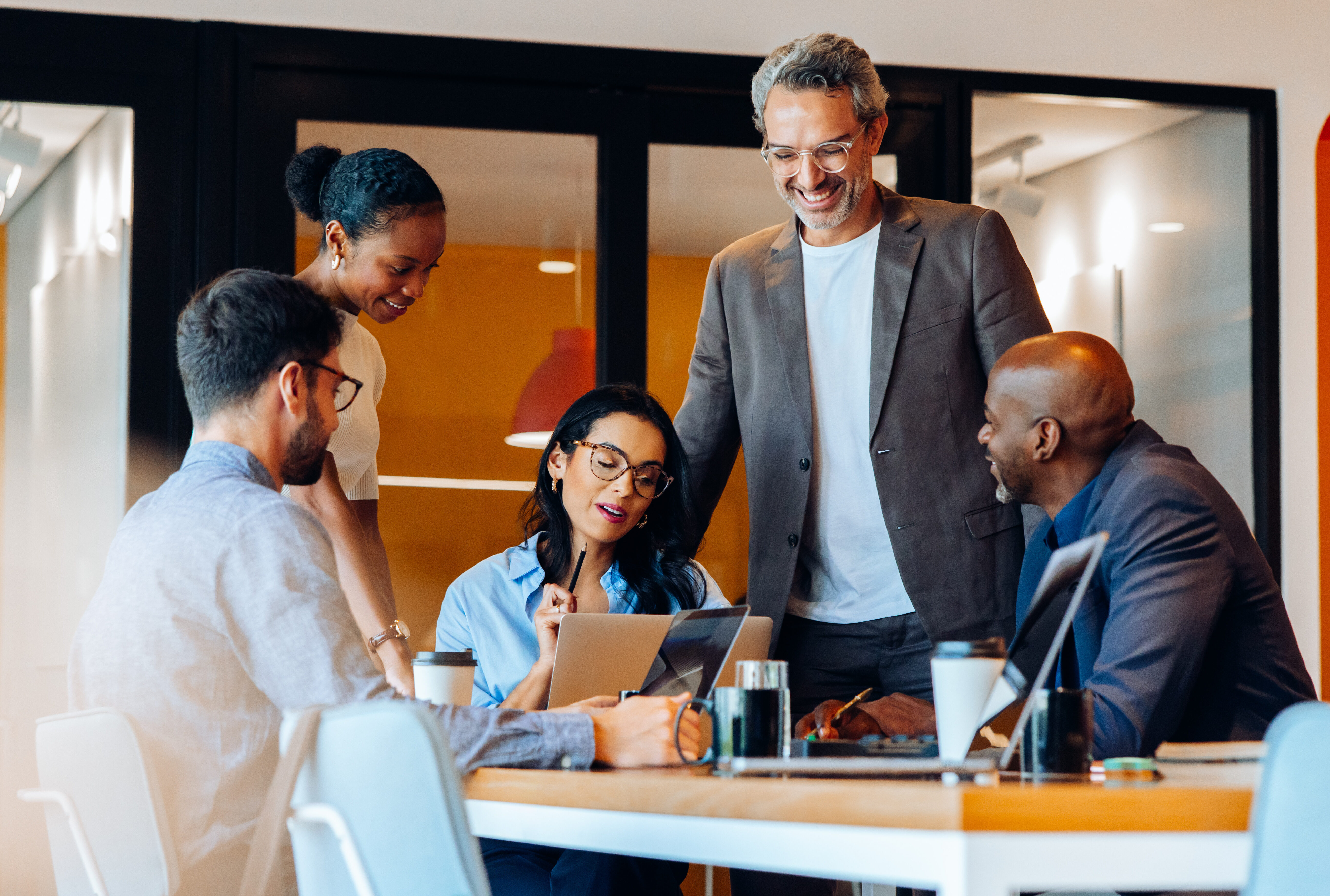 Diverse group of professionals gathered around a table in discussion.